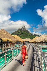 Luxury hotel vacation Tahiti resort travel honeymoon destination tourist woman walking on boardwalk...