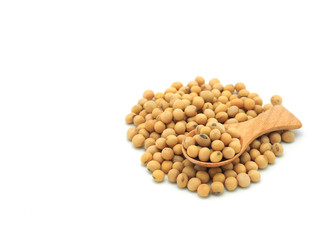 Soybeans in wooden spoon on pile isolated on white background.