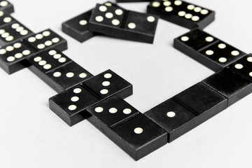 Black old, vintage dominoes on a  cardboard  background. The concept of the game dominoes. Selective focus