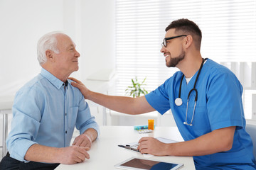 Doctor examining senior patient in modern office