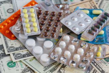 Pills on a background of money. Selective focus