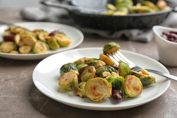Delicious roasted brussels sprouts with red beans and peanuts served on grey marble table