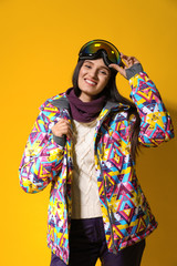 Fototapeta premium Woman wearing stylish winter sport clothes on yellow background