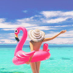 Happy summer vacation fun woman tourist enjoying travel holidays ready for swimming with flamingo...