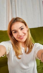 Beautiful healthy smiling mixed race female taking selfie at home.