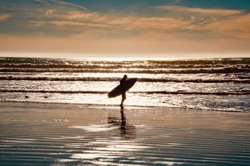 Fototapeta na wymiar Surfers on the wooden pier of Pismo Beach in California