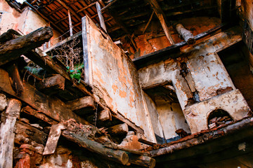 Fototapeta na wymiar Interior of a collapsed house full of broken plants and beams