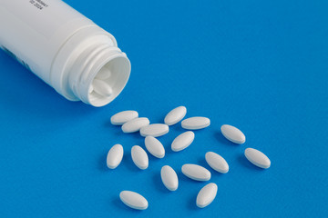 Tablets are poured out of the bottle. Selective focus.