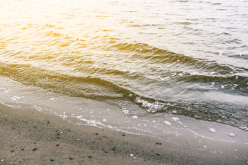 Sand beach and shore wave texture. Wave on the sandy beach.