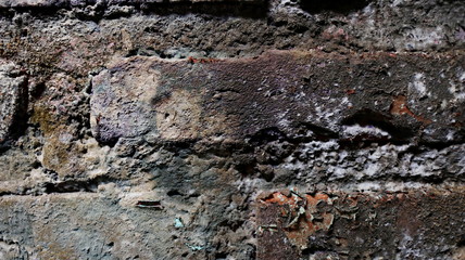 The brick walls are weathered dirty and full of dust                               