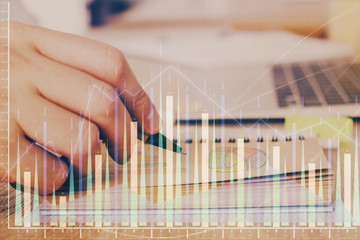 Multi exposure closeup hands with stock market forex graph.