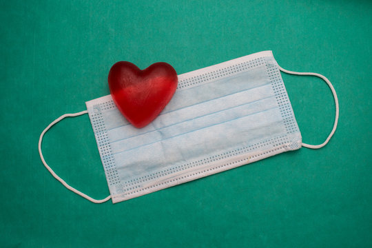 Medical Mask And Heart On A Green Background