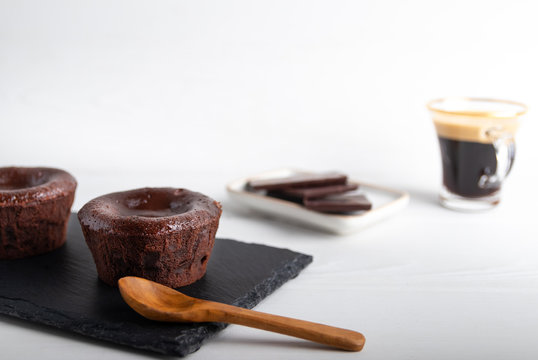 Warm Chocolate Lava Cake On A Black Plate With A Cup Of Coffee On A White Background