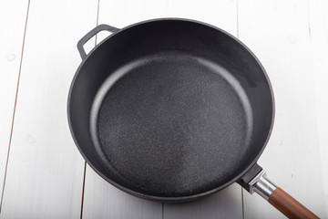 Cast-iron wok pan on a white table.