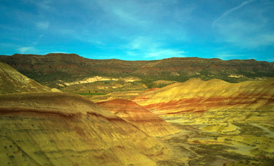 Fototapeta na wymiar Breathtaking colorful John Day Fossil Beds Painted Hills with red green black orange and yellow stripes in a semi desert landscape in Oregon