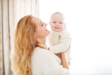 tender Caucasian mother holds baby in the air