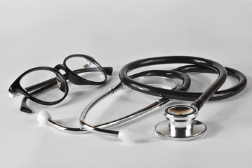 Stethoscope with glasses on a white background. Medical equipment on the table.
