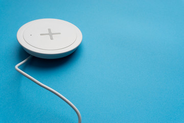 Charging pad or dock on blue background.Wireless charging and copy space