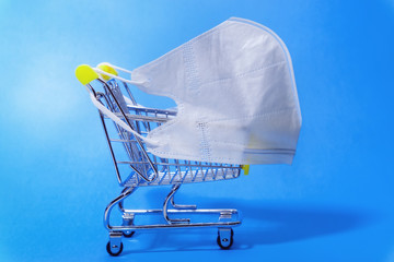 cart and white medical masks on a blue background. Protection against viruses and infections....