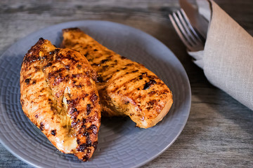 Grilled chicken fillet on a gray plate. Close-up.