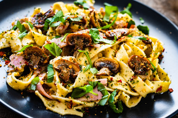 Tagliatelle with ham and chmpignon wooden table