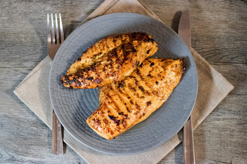 Grilled chicken fillet on a gray plate. Close-up.