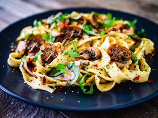 Tagliatelle with ham and chmpignon wooden table