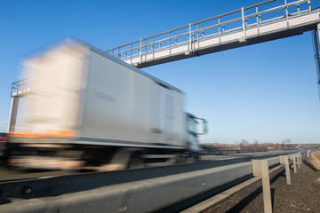 Fototapeta na wymiar Truck passing through a toll gate on a highway, highway charges, motion blurred image
