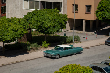 old fifties vintage car parked by apartments