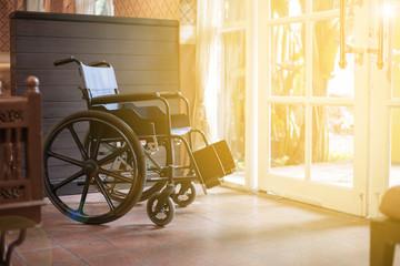 Fototapeta na wymiar Empty wheelchair in front of the hospital or restaurant with sunrise effect. Preparing for disable customers or patient