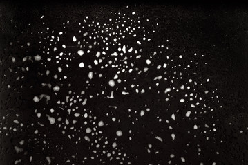 Texture of frozen glass. Wet cold glass on black background.