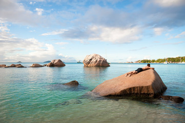Man resting on granite boulder landscape in the Seychelles