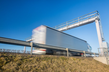Truck passing through a toll gate on a highway, highway charges, motion blurred image