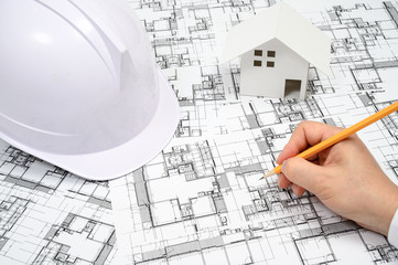 A man who holds a pencil in his hand and paints architectural drawings.