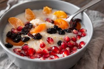 plate of oatmeal with Mandarin slices, pomegranate seeds, raisins, dried apricots,