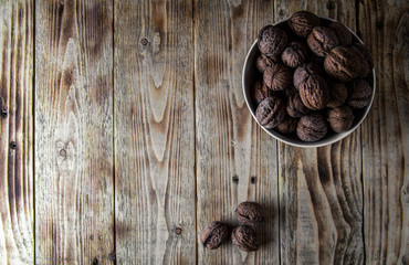 a white plate of walnuts on a wooden table