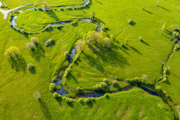 Forest in summer colors. Green deciduous trees and winding blue river in sunset. Soomaa wooded meadow, Estonia, Europe