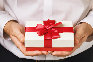 A man with a gift in his hands close-up. Holidays concept
