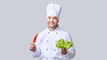 Chef Holding Pepper And Salad Leaves Standing, Gray Background, Panorama