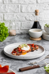 Sandwich with red fish, poached egg, balsamic vinegar and micro-greens