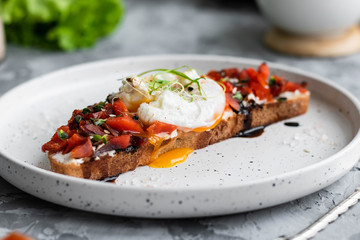 Sandwich with red fish, poached egg, balsamic vinegar and micro-greens