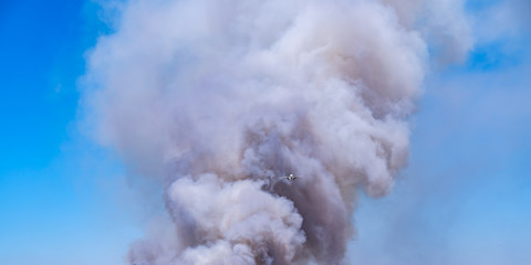 aircraft fly pass through fire and giant smoke