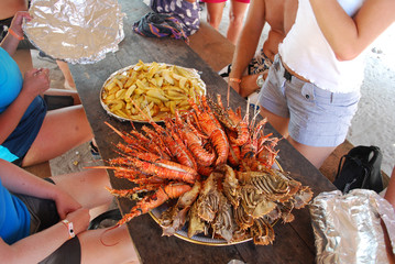 Colourful seafood meal on a table including Crayfish lobster and chips