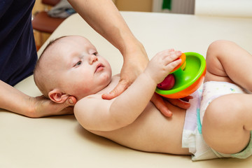 Pediatric Physical Therapy - an infant exercising on a table