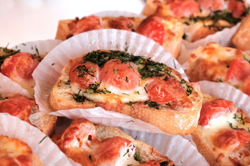 Appetizers bruschetta with tomatoes and cheese on a banquet table.