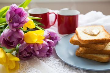 Great breakfast. Two cups of coffee, toast with peanut butter and a beautiful bright bouquet of tulips.