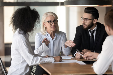Businesslady giving instructions telling about corporate goals to multiracial staff