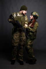Twol soldiers in camouflage clothing poses in a Studio