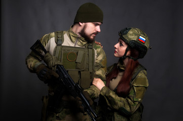 Twol soldiers in camouflage clothing poses in a Studio