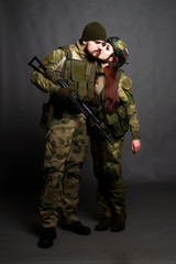 Twol soldiers in camouflage clothing poses in a Studio